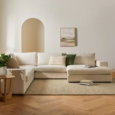 a living room with a white couch and wooden flooring next to a wall mounted painting