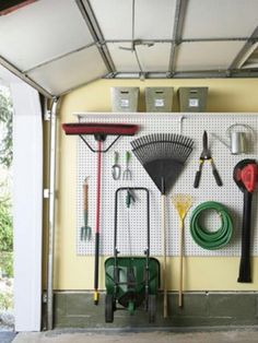 a garage filled with lots of different types of tools and equipment on the wall next to an open door