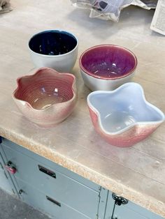 three bowls sitting on top of a counter next to each other in different shapes and sizes