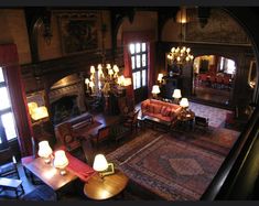 a living room filled with lots of furniture next to a fire place and chandelier