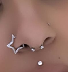 a woman's nose with two piercings on it