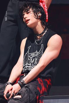 a young man sitting on top of a stage wearing a bandanna around his head