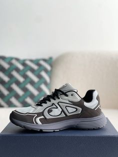 Embrace a sleek and sporty aesthetic with these Dior B30-inspired sneakers in a sophisticated grey and anthracite colorway. Crafted with breathable mesh and technical fabric, these shoes are perfect for those who value both style and performance. The lightweight construction and sculpted rubber sole ensure all-day comfort and support, while the signature "CD30" logo adds a touch of Dior's iconic style. Whether you're hitting the gym or the streets, these sneakers will elevate your look with a to Casual Running Sneakers With Reflective Logo, Gray Running Shoes With Reflective Details, Gray Running Shoes With Abzorb Midsole, Gray Functional Running Shoes With Reflective Details, Modern Gray Sneakers With Reflective Details, Modern Gray Running Shoes For Streetwear, Modern Gray Mesh Sneakers, Gray Dynamic Mesh Sneakers, Dynamic Gray Mesh Sneakers