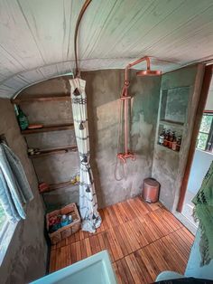 a bathroom with wooden floors and a shower head in the corner next to a window