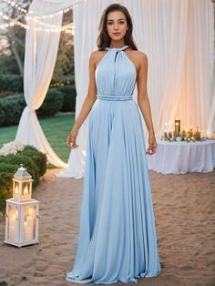 a woman wearing a blue dress standing in the sand