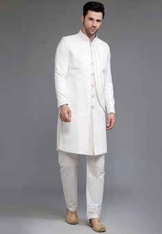 Ready-made Suede Sherwani in Off White Color. Crafted in Chinese Collar and Full Sleeves, this Ready-made attire with Satin Lining is Enhanced with Buttons, Pockets and Thread Work. Available with a Cotton Silk Pant in Off White Color.   Do note: Footwear and Stole shown in the image is for presentation purposes only. Half to one inch may vary in measurement. (Slight variation in actual color vs. image is possible) We sell all kinds of Menswear. Mens Sherwani | Mens Sherwani Set | Traditional Me Vs Image, Mens Sherwani, Silk Pant, Dhoti Pants, Chinese Collar, Indian Festivals, Silk Pants, Thread Work, Off White Color