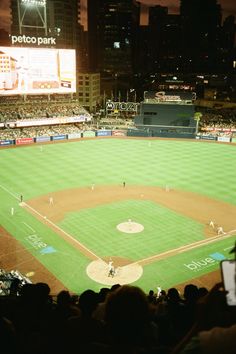 a baseball game is being played in a stadium with many people watching from the stands