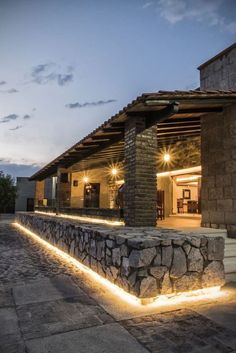 an outdoor area with stone walls and lights on the outside, along with steps leading up to it