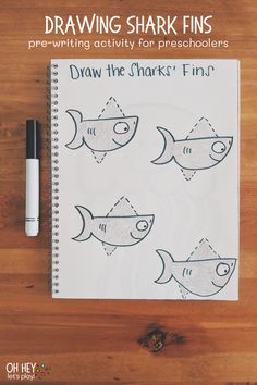 a notebook with drawings of sharks on it and the words drawing shark fins written in black ink