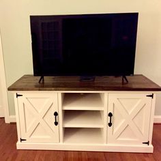 a flat screen tv sitting on top of a wooden entertainment center