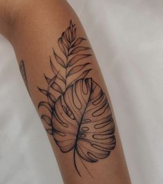 a black and white photo of a leaf tattoo