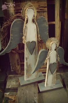 two wooden angel figurines with hearts on them