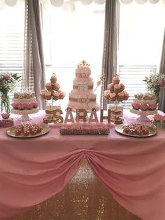 a table topped with lots of pink and gold desserts