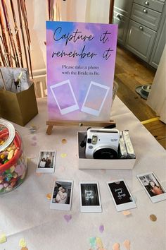 a table topped with photos and a sign that says capture it, rereasher it