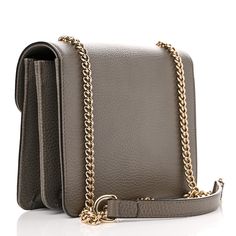 This is an authentic GUCCI Dollar Calfskin Small Interlocking G Shoulder Bag in Loess. This chic shoulder bag is crafted of grained calfskin leather in grey. The tote features a light gold chain-link shoulder strap and a facing flap with a matching gold interlocking GG logo flip-lock. This opens to a partitioned natural fabric interior with a patch pocket. Gg Logo, Natural Fabric, Natural Fabrics, Chain Link, Gold Chain, Patch Pocket, Gold Chains, Calf Skin, Shoulder Strap