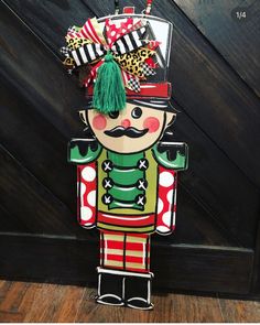 a wooden nutcracker with green hair and mustache