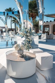 a table with flowers and candles on it in front of a pool