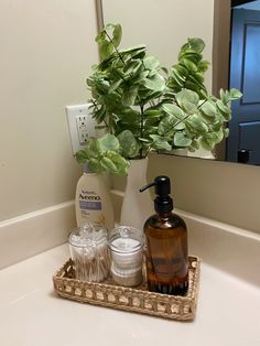 a bathroom sink with a soap dispenser and two glasses