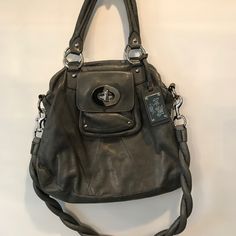 Gorgeous Rare Coach Kira Handbag With Twisted Rope Shoulder Strap. Charcoal Leather In Great Condition! Large Silver And Leather Coach Nameplate, Large Exterior Pocket With Turn Key Clasp. Dual Interior Spaces With Zipper Closures. One Side Of Interior Features A Zippered Pocket With 2 Additional Pockets And The Other Side Features 2 Additional Interior Pockets. Super Chunky Twisted Leather Rope Strap Is Magnificent! Can Be Worn As Shoulder Bag, Crossbody Or As A Satchel. Dust Bag Included! Silver Top Handle Shoulder Bag With Gunmetal Hardware, Gray Shoulder Bag With Palladium Hardware For Everyday, Travel Silver Satchel With Handles, Silver Top Handle Bags With Gunmetal Hardware, Silver Travel Satchel With Handles, Coach Silver Shoulder Bag, Silver Travel Satchel, Formal Gray Bag With Silver-tone Hardware, Coach Silver Shoulder Bag With Branded Hardware