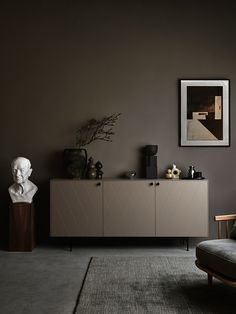 a living room with a couch, sideboard and art on the wall in it