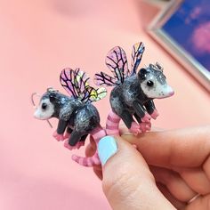 two miniature possles are sitting on top of each other in front of a pink background