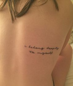 a woman with a tattoo saying i belong deeply to yourself on her upper back shoulder