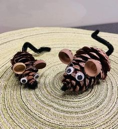 two pine cone mice sitting on top of a table next to each other with googly eyes