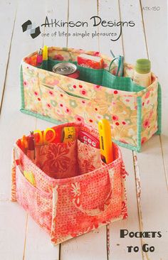 two storage bins sitting on top of a wooden floor next to each other with pens and pencils in them