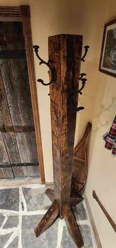 a tall wooden object sitting on top of a tile floor next to a door and chair