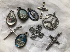 "These are old religious charms that can be put on a chain or charm bracelet. The largest circular one with Mary, Joseph and baby Jesus is marked sterling as is the square openwork cross. The charms encased in glass are silver plate and brass. The  other crosses are gold or silver plated.  All are included for the price. The circular charm is 1.25\" in diameter and all are at least 1\" long." Antique Nickel-free Cross Pendant Jewelry, Silver Cross Pendant With Miraculous Medal, Silver Cross Jewelry With Miraculous Medal, Silver Charms Jewelry For Commemoration, Silver Miraculous Medal Cross Pendant Jewelry, Silver Jewelry With Charms For Commemoration, Commemorative Silver Charm Jewelry, Commemorative Silver Jewelry With Charms, Silver Commemoration Jewelry With Charms