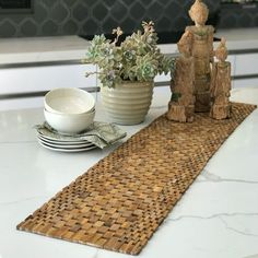 there is a place mat on the table with two small statues and a plate next to it