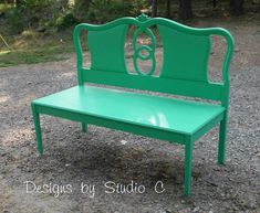 a green bench sitting on top of a gravel field