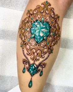 a woman's leg with a tattoo on it and an aqua heart in the center