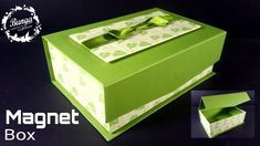 an open green box with a bow on the front and inside, sitting on a black surface