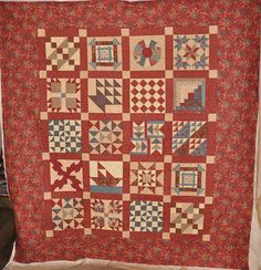 a red and blue quilt hanging on a wall