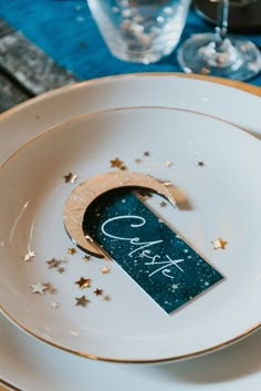 the table is set with white plates and gold rimmed place settings, which have stars on them