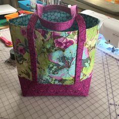 a bag sitting on top of a table next to a sewing machine and cutting board