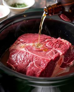 the meat is being poured into the slow cooker to cook it for dinner or as an appetizer