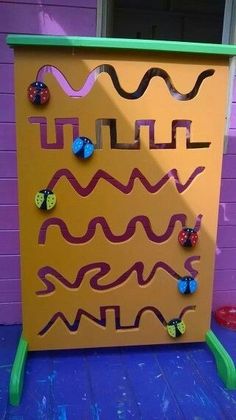 a yellow board with butterflies on it sitting in front of a purple wall and blue floor