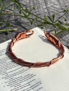 Handmade 100% pure 16 gauge solid copper bangle.  Beautiful spiral design accent over a thick band.  The bangle measures 9 inches in length and will comfortably fit a 6-8 inch wrist size.  bangle can be pulled open and pinched close to customize size.  Keep in mind the copper will patina and this piece will look stunning as it darkens! The last two images are of a previously made piece that has aged for some time!  My jewelry can be worn at all times to obtain healing benefits of copper.All of my jewelry is handmade and nonrefundable.  I encourage you to reach out with any questions if you are unsure about a piece! I am more than happy to answer and send additional pictures etc.  I cannot allow refunds due to a number of factors. Copper and brass patina very quickly also, a piece that has Bohemian Copper Wire Cuff Bangle Bracelet, Handmade Copper Wire Cuff Bangle, Handmade Copper Wire Cuff Bracelet Bangle, Handmade Rose Gold Copper Cuff Bracelet, Handmade Copper Spiritual Bangle, Handmade Copper Bangle In Brown, Handmade Brown Copper Bangle, Rose Gold Copper Bangle Cuff Bracelet, Rose Gold Copper Cuff Bangle