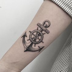 an anchor and steering wheel tattoo on the arm