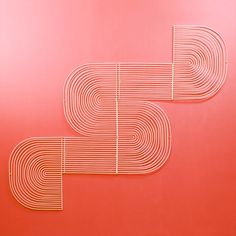 two pieces of metal on a red surface with lines in the shape of letters and numbers