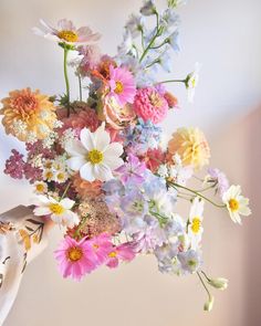 a woman holding a bouquet of colorful flowers