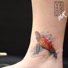 a small turtle tattoo on the foot of a woman's leg with watercolors