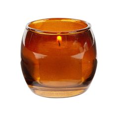 a brown glass candle holder on a white background with a single burning candle in the center