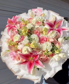 a bouquet of pink and white flowers in someone's hand