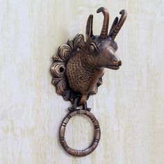 an animal head mounted to the side of a wall with a ring on it's end