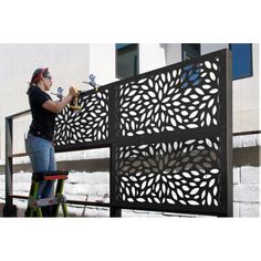 a woman is working on an outdoor screen with a scaffolder in front of her