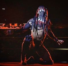 a man with dreadlocks standing in front of a crowd at a wrestling match