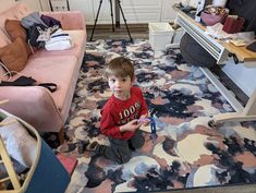 a young boy sitting on the floor in his living room